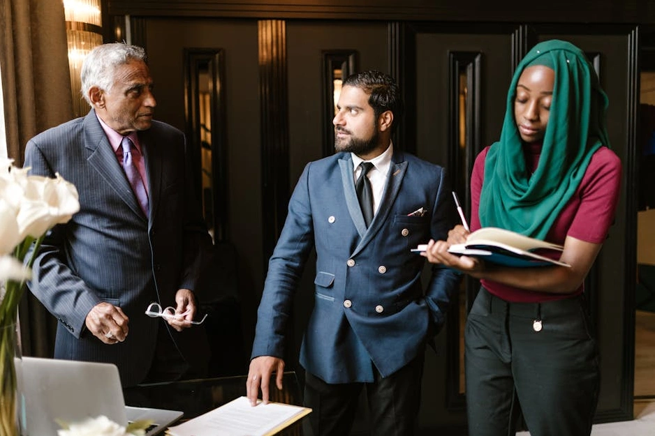 A diverse group of business professionals collaborating around a table in a bright, modern meeting room.